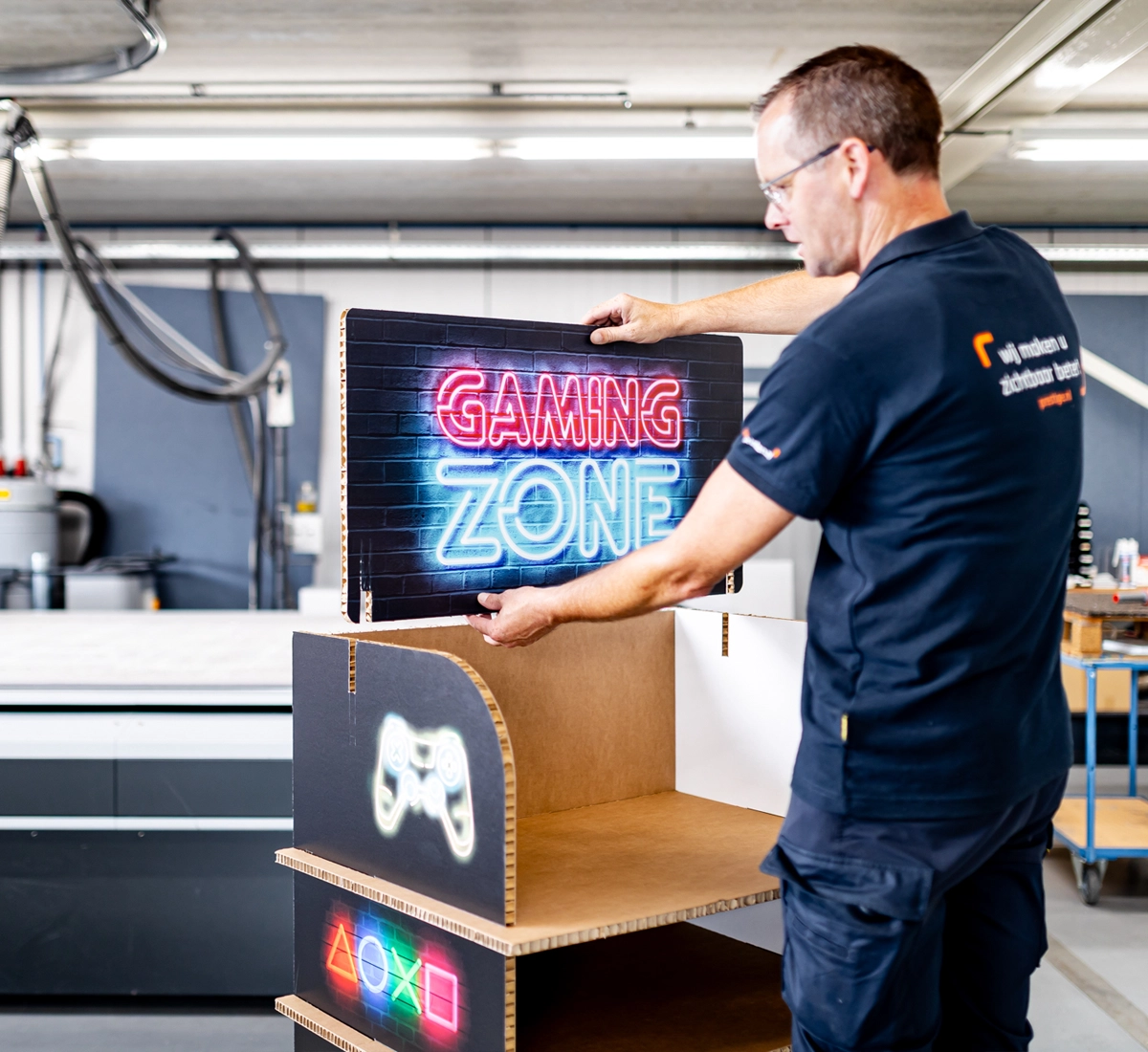 De laatste hand wordt gelegd aan het in elkaar zetten van een display door een productiemedewerker van Prestige Reclame.