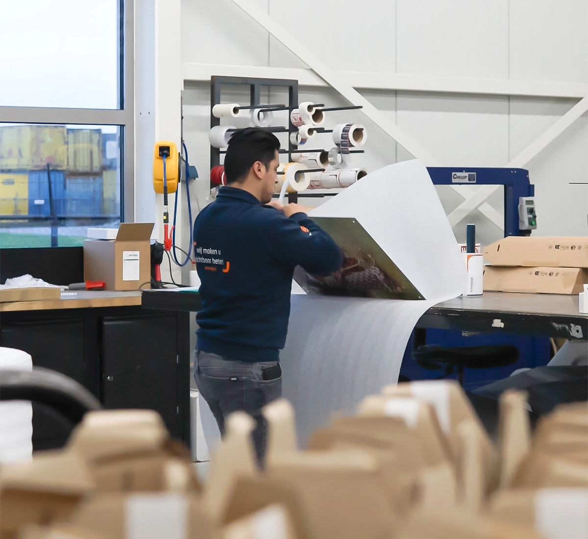 Een fotopaneel wordt zorgvuldig ingepakt door een productiemedewerker voor verzending.