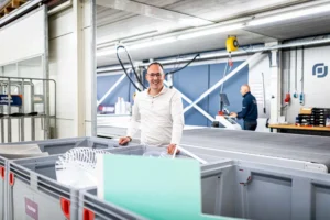 Directeur Bernard van Rees voor de recycling bakken van Prestige Reclame.