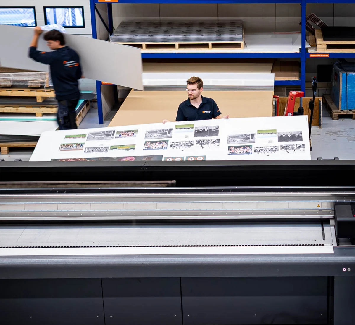 Print Prestige Reclame 17 Medewerker in de productiehal haalt een grote print van de printer.